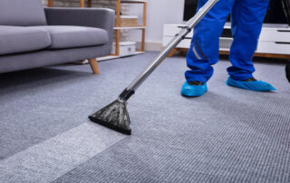 This image shows a man cleaning a carpet.